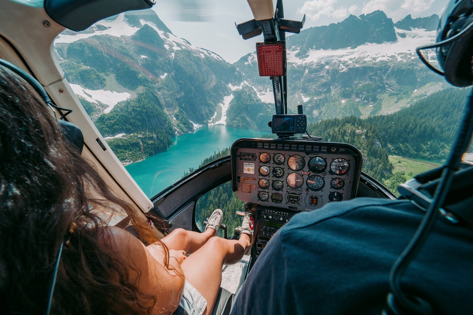 View of glacier-fed lake from inside a helicopter cockpit