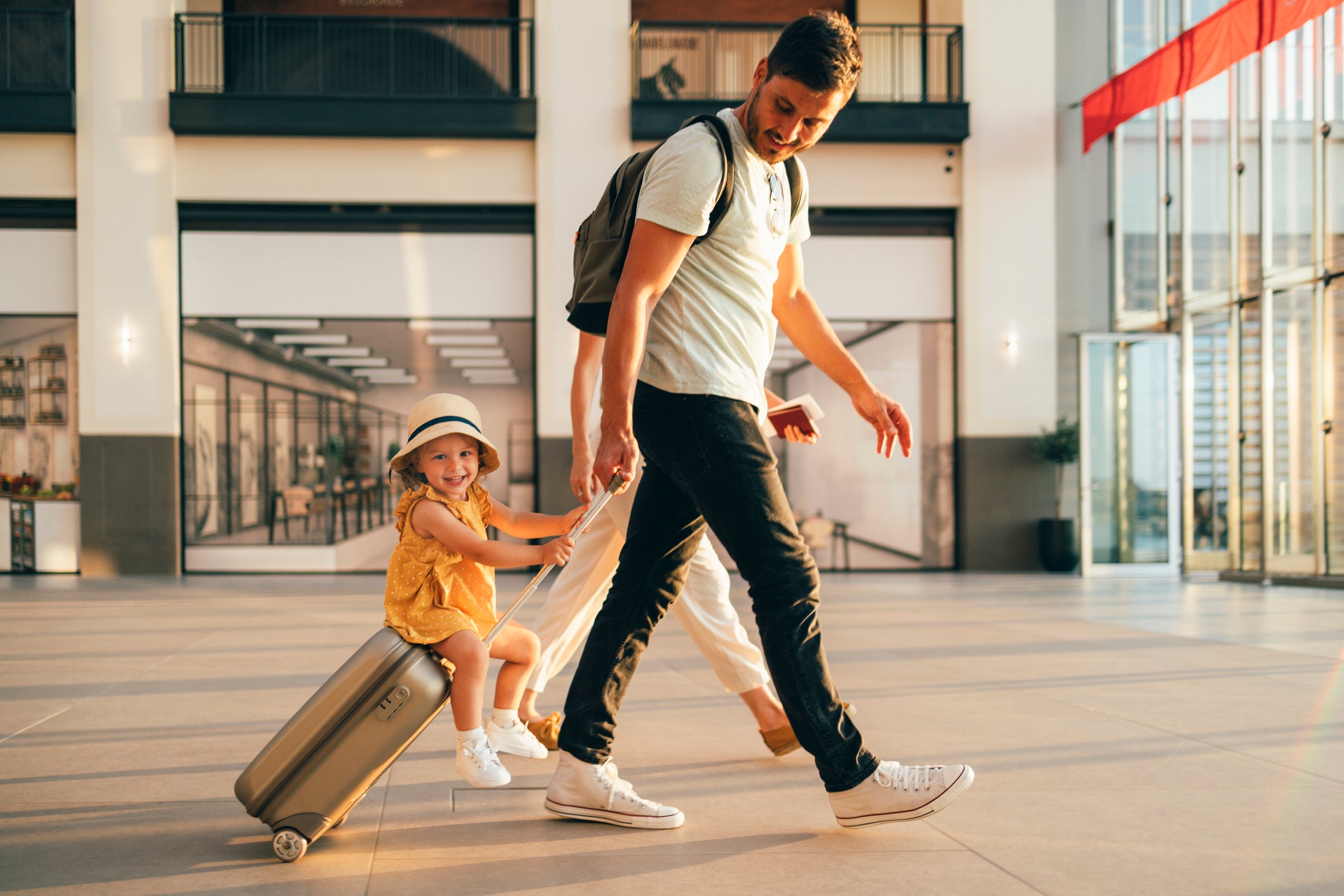 father and daughter walking through airport