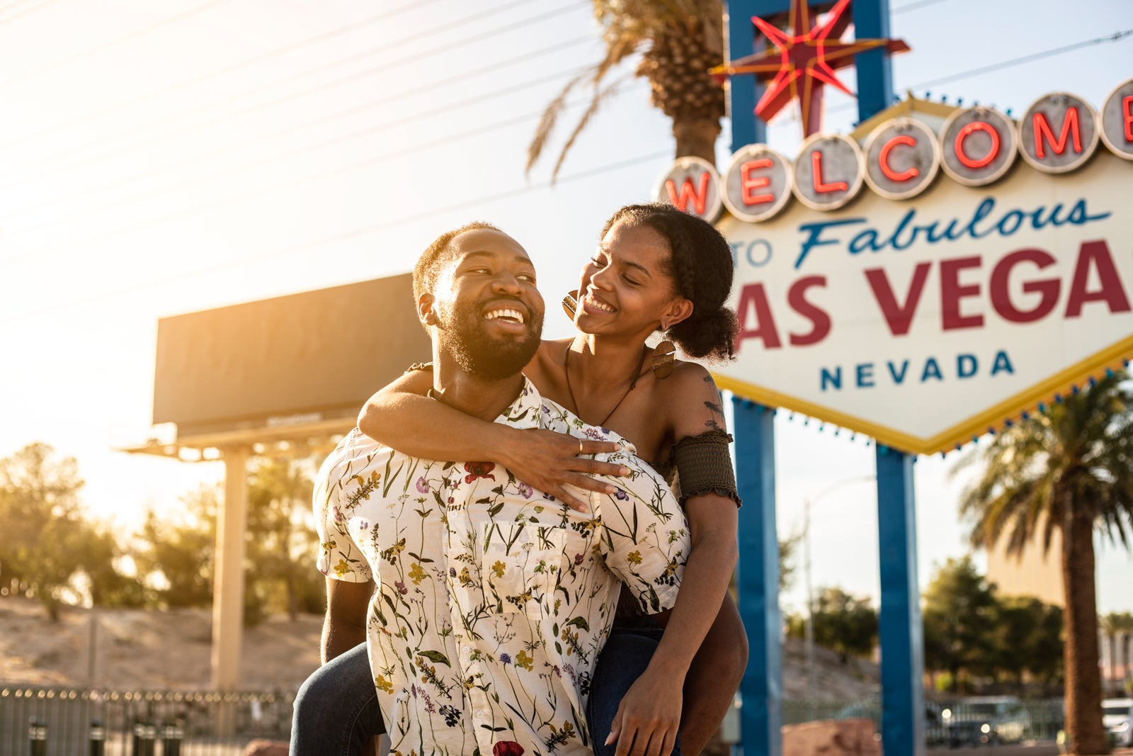 A young couple in front of the Welcome to Las Vegas sign