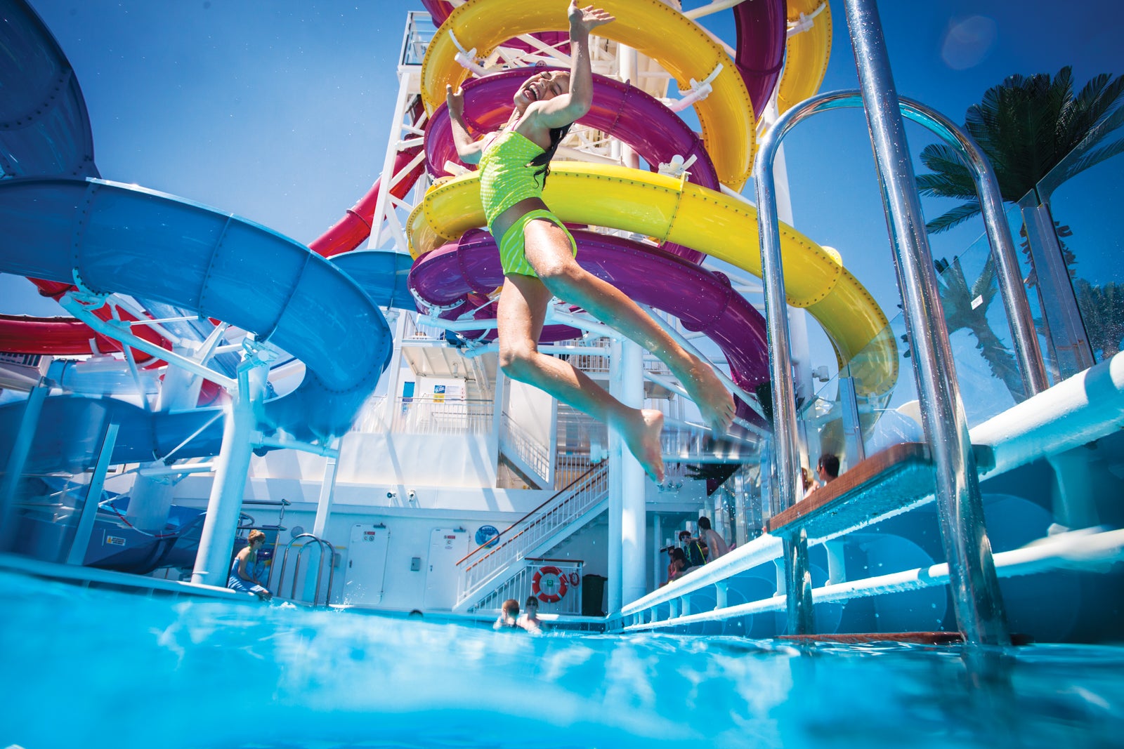 Girl jumping into pool by twisting water slides