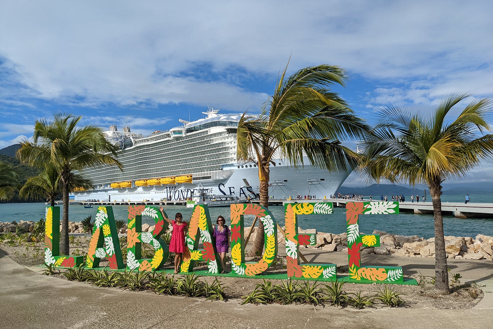 Colorful sign spelling out Labadee framed by palm trees with Royal Caribbean's Wonder of the Seas in the background