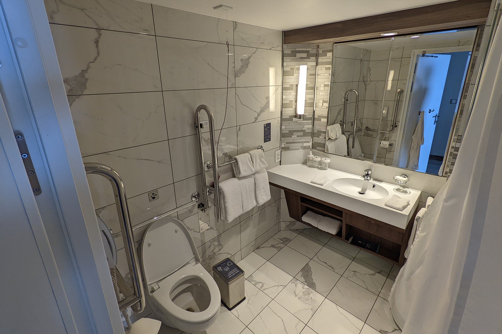Accessible cruise ship bathroom with white tiles