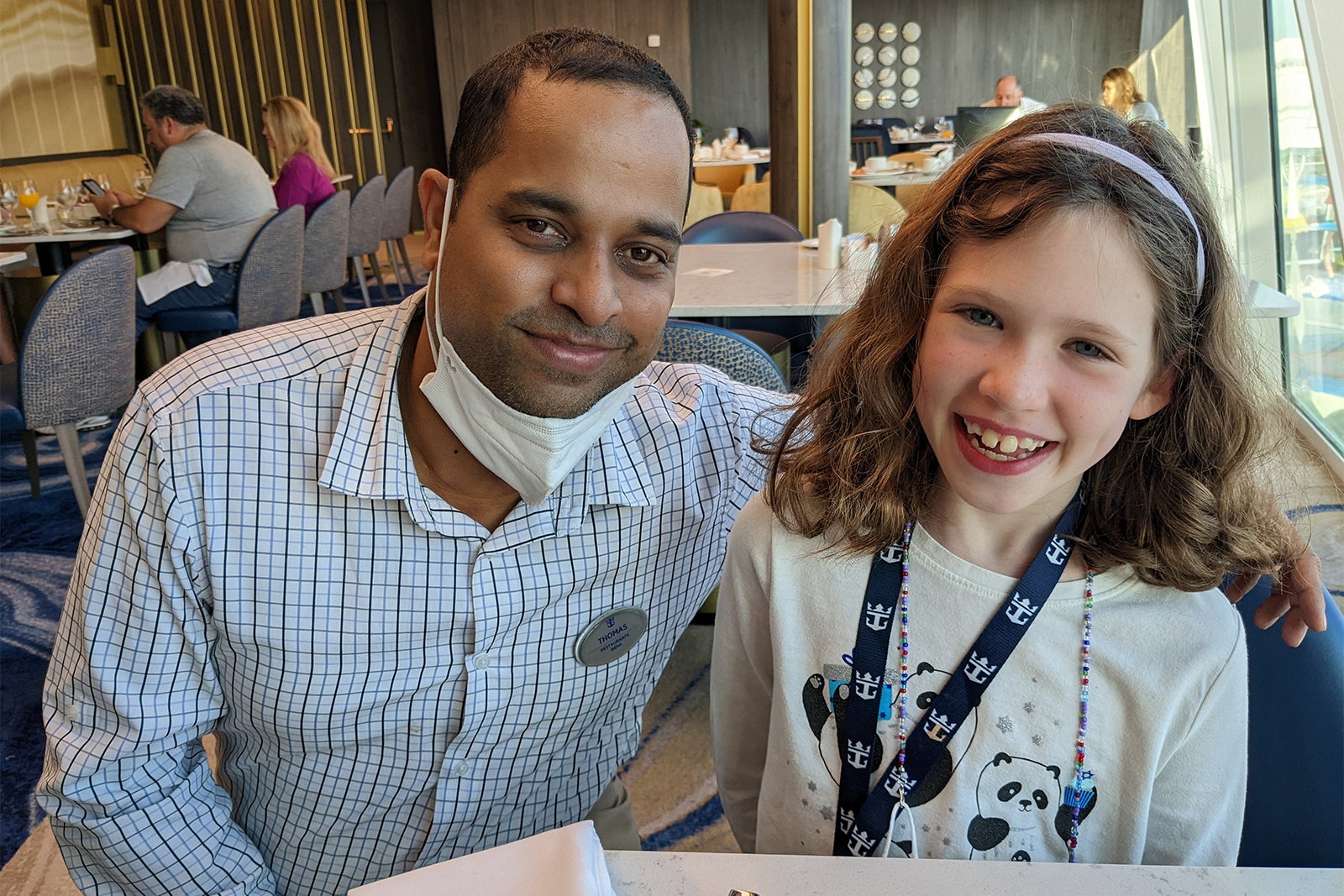 Young girl posing with waiter on cruise ship