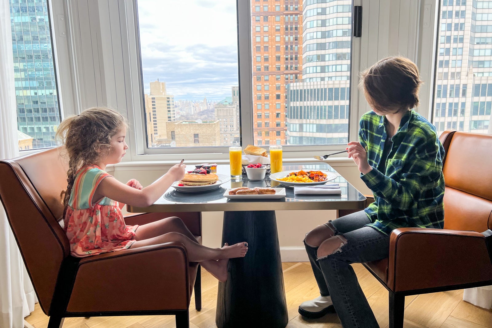 Two kids at a breakfast table at a hotel