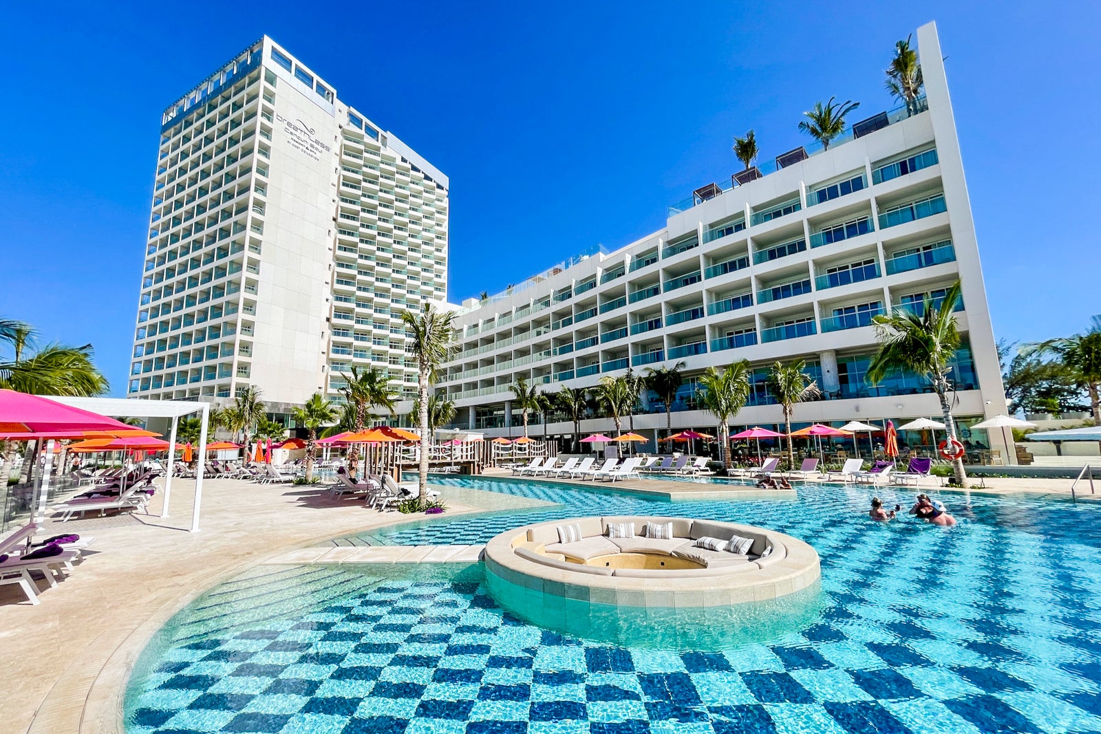 a hotel pool in foreground with large hotel towers in the background