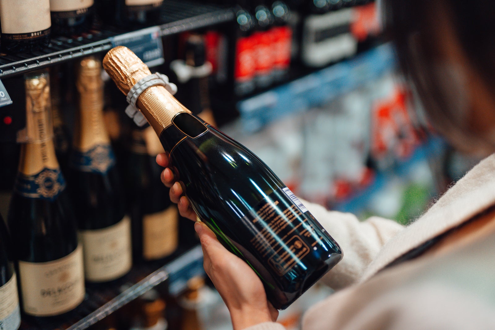 Woman choosing champagne in liquor store