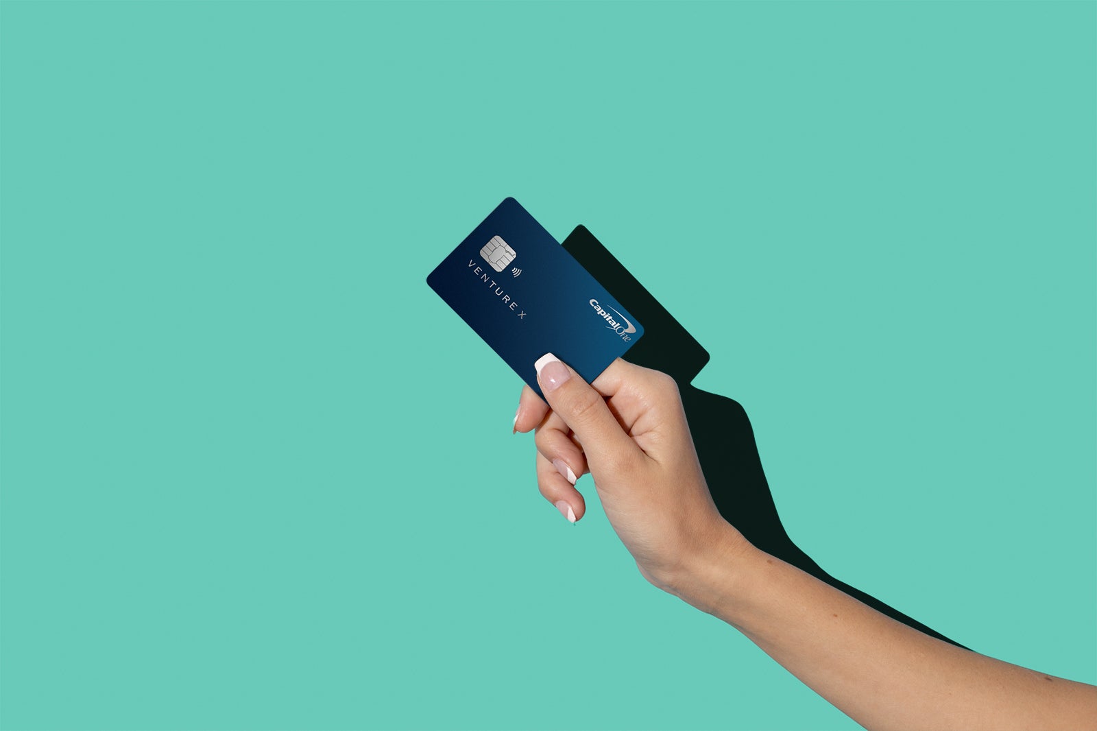 a hand holds the Capital One Venture X card