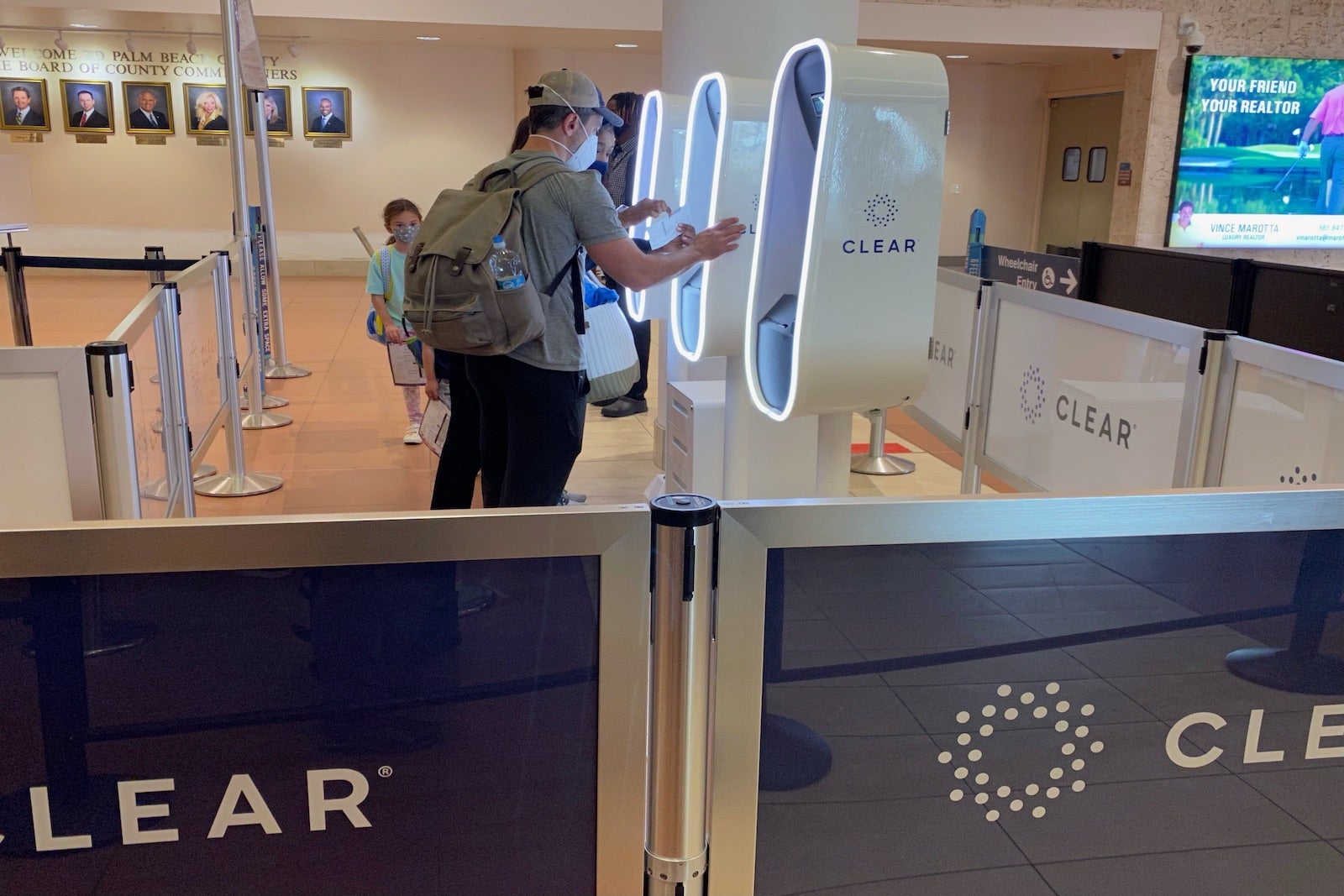 travelers approach Clear kiosks at an airport