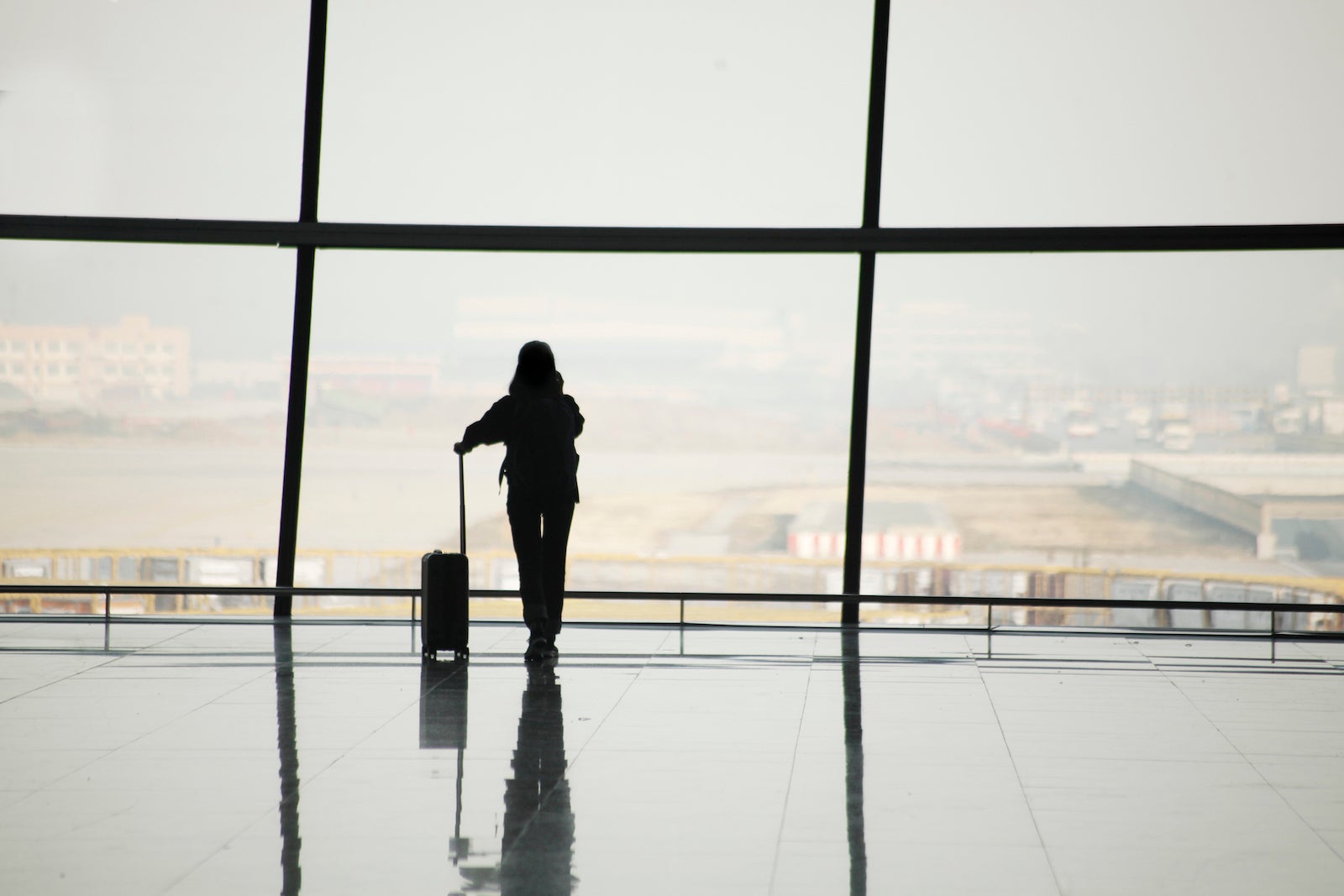 Silhouette of woman at airport window