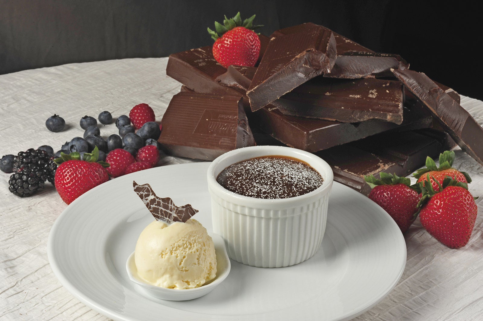 Carnival's chocolate melting cake on a white plate beside a small scoop of vanilla ice cream