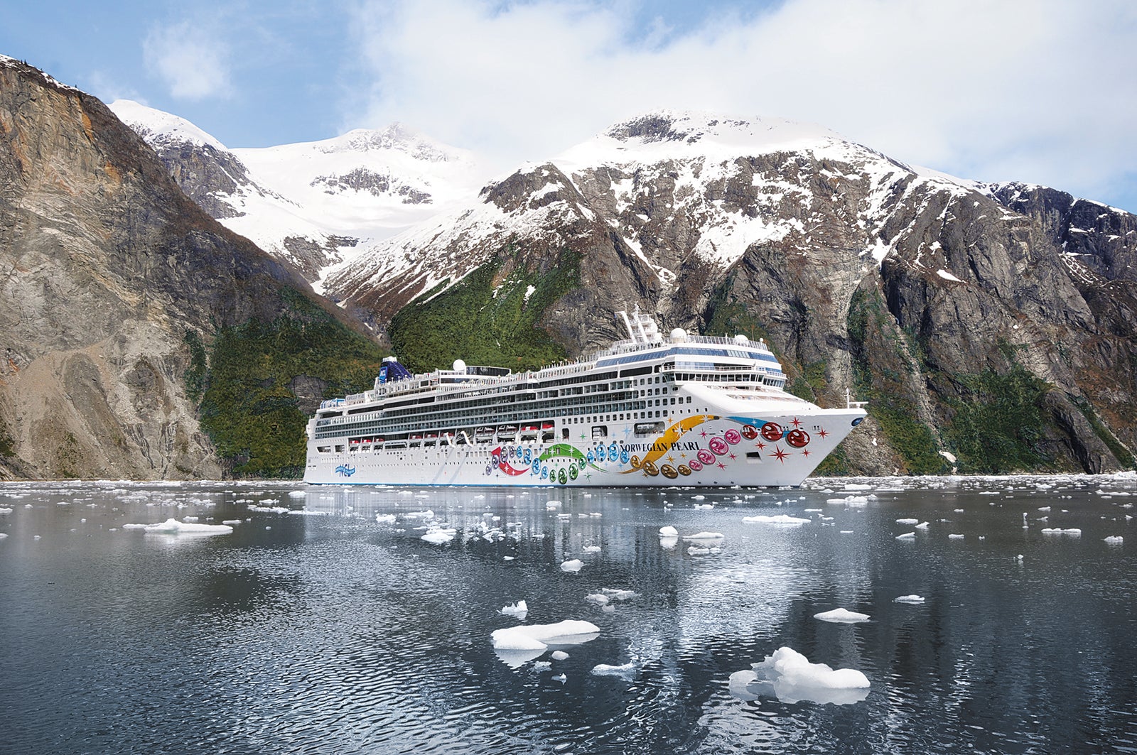 Cruise ship set against Alaska mountains with ice in the water