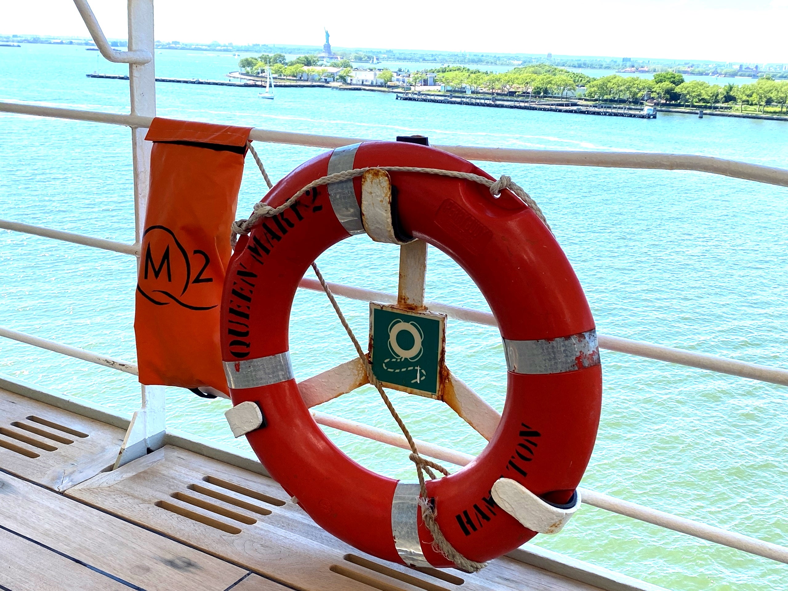 A life ring from Cunard's Queen Mary 2 cruise ship with the Statue of Liberty in the background. 