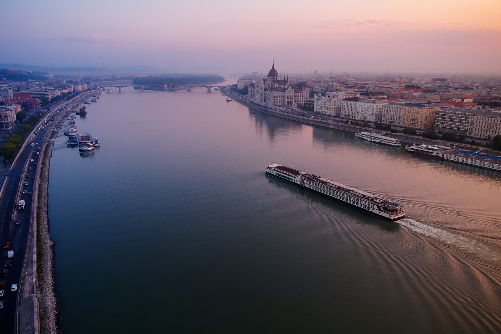 A river cruise going past the Hungarian Parliament Building in an early morning.