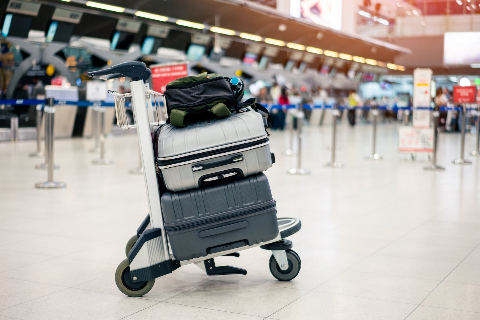 a luggage cart loaded with bags at an airport check-in counter