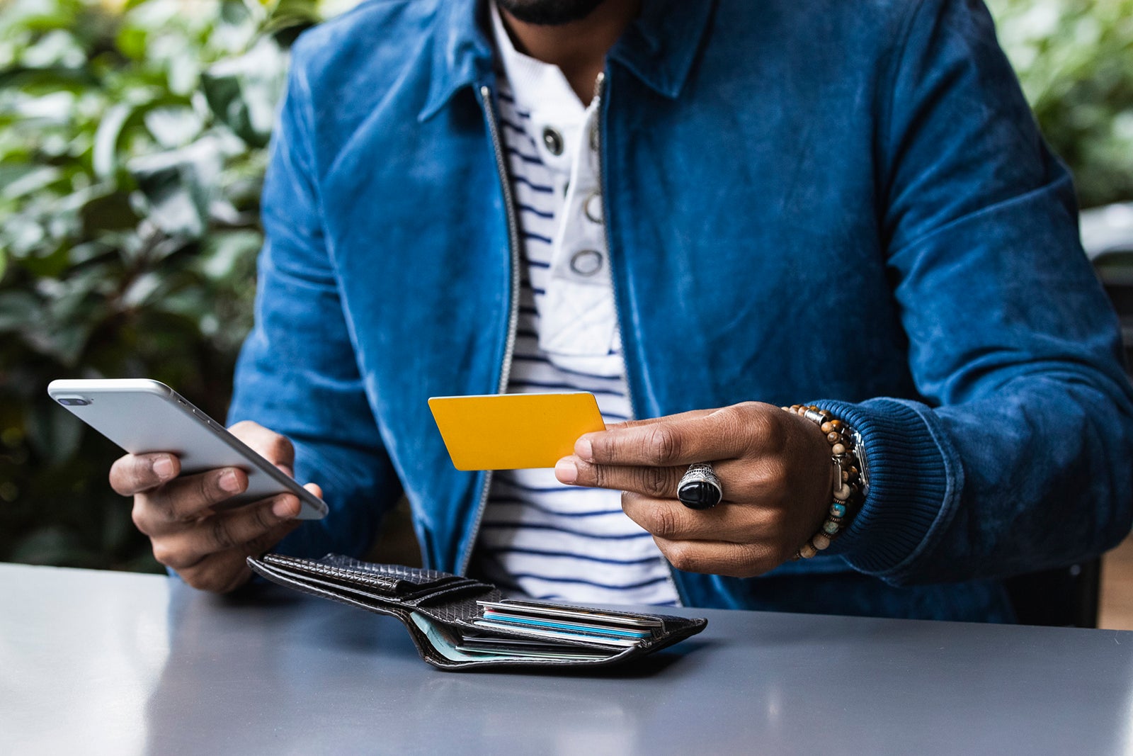 A man holds a credit card while making a phone call