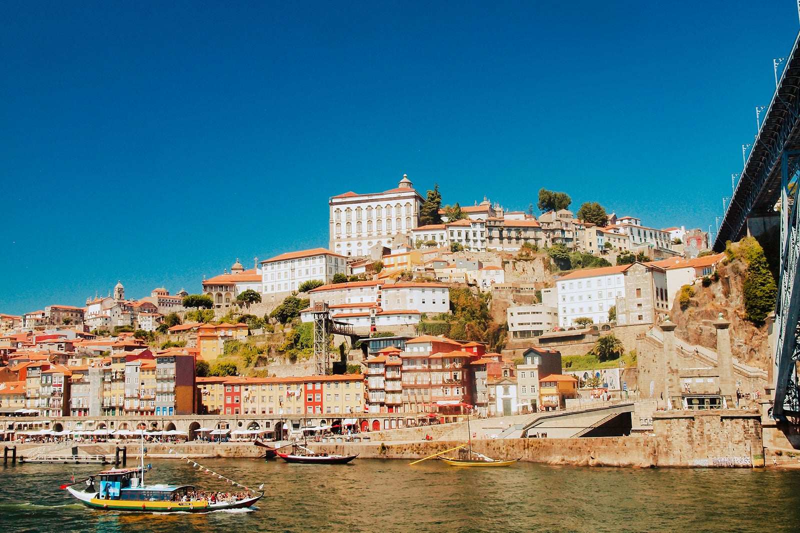 A portion of Porto, Portugal, as it rises up over the Douro River with blue sky behind it