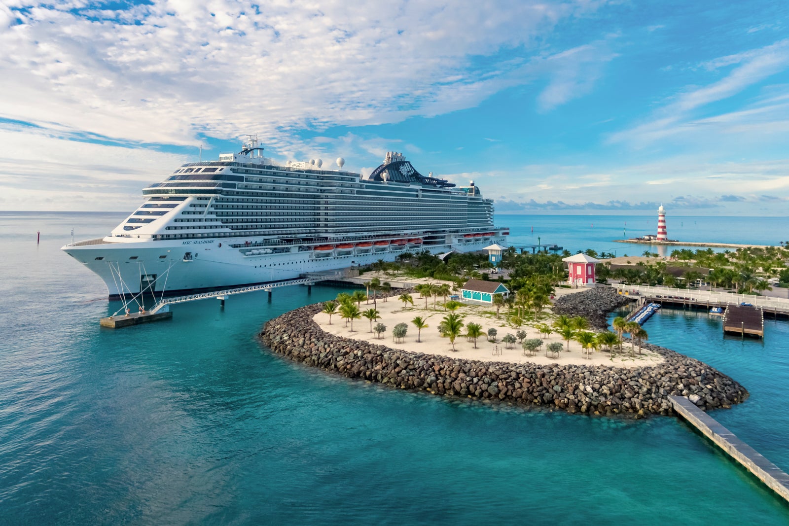 MSC Seashore cruise ship docked at a palm-tree dotted island