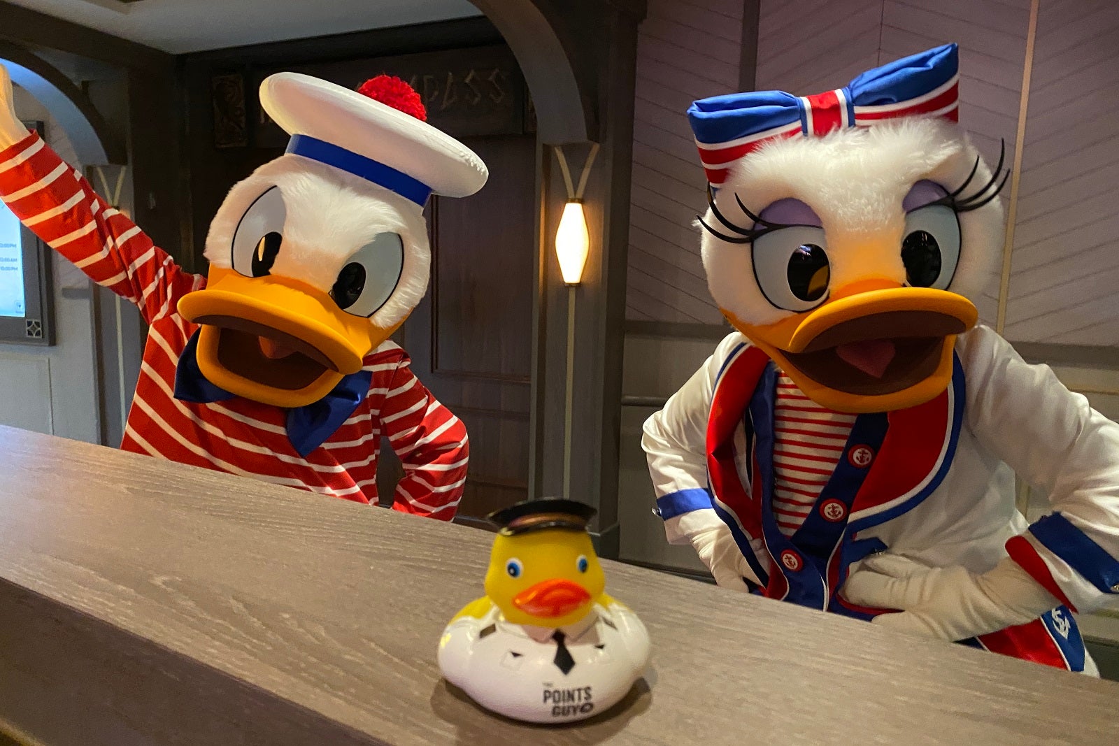 Donald and Daisy Duck posing with a TPG rubber duck on Disney Wish