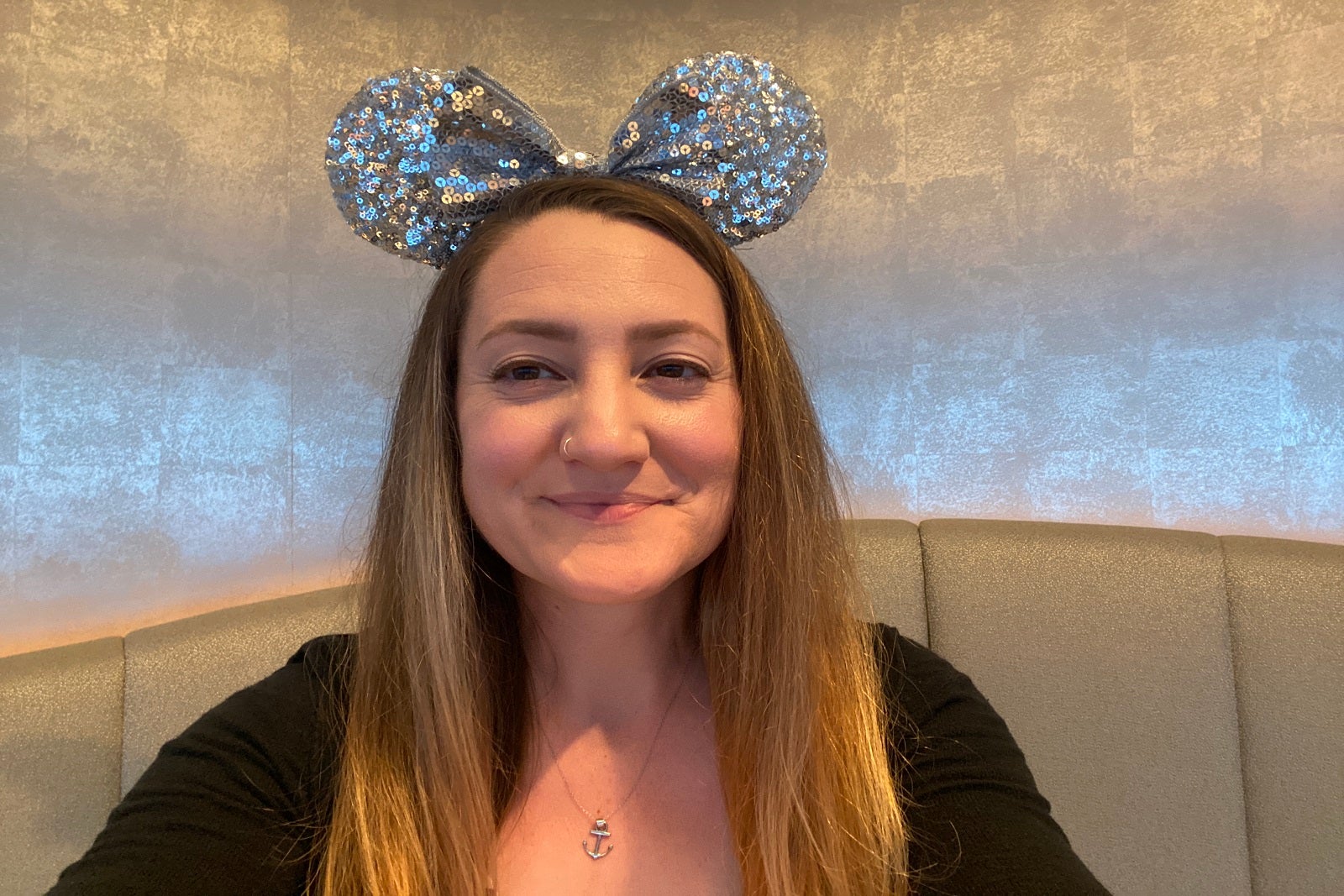 A photo of a woman wearing glittery Minnie Mouse ears