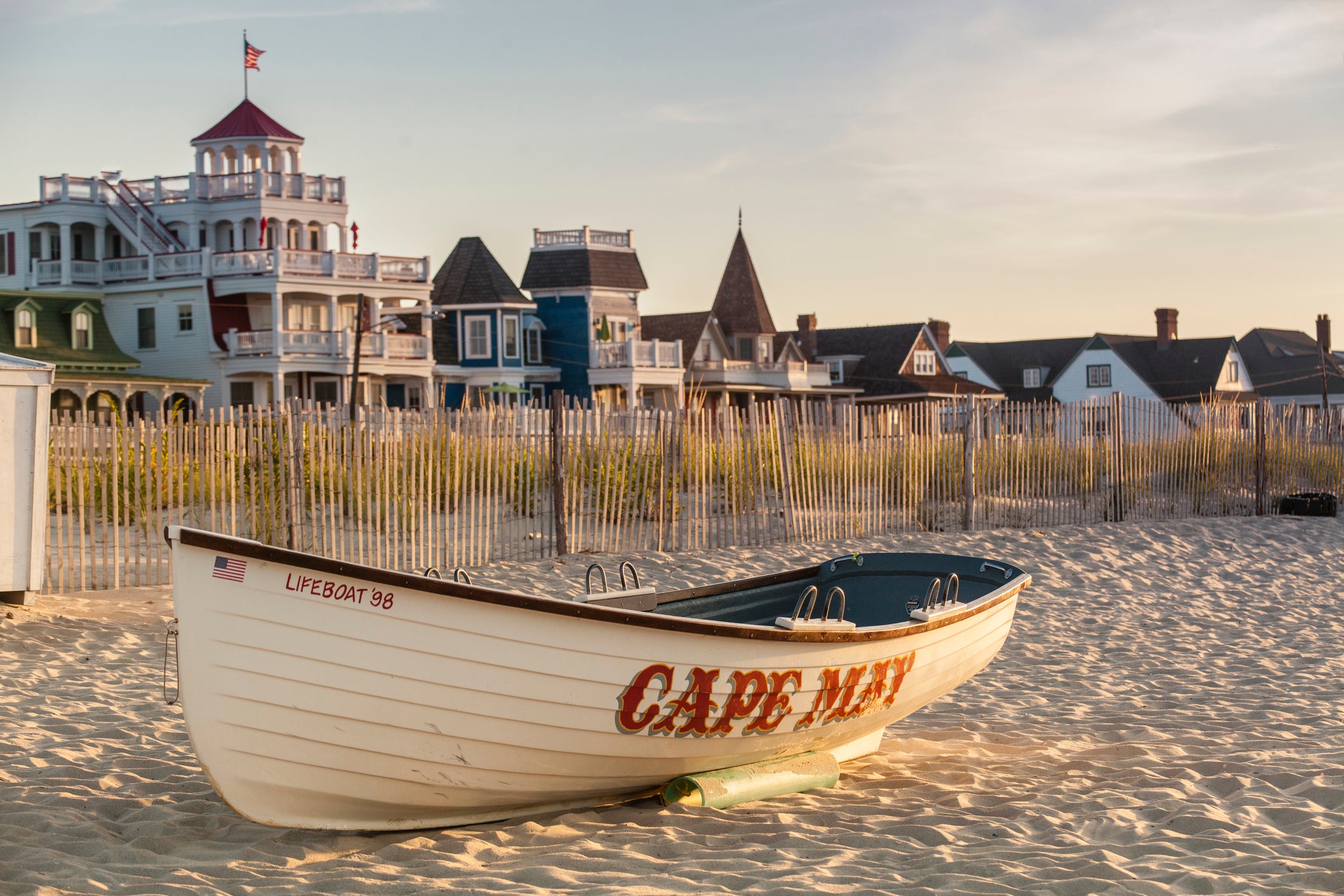 a small wooden boat with Cape May written on the side sits on the beach