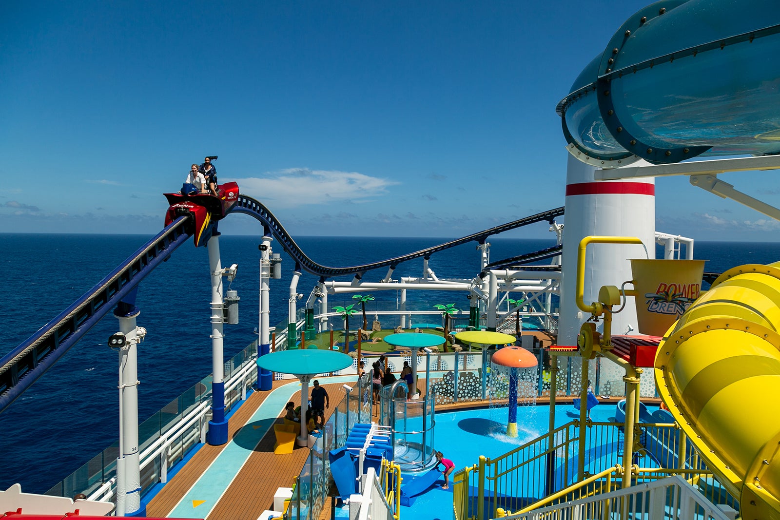 People riding Bolt rollercoaster above a water park on Mardi Gras cruise ship.