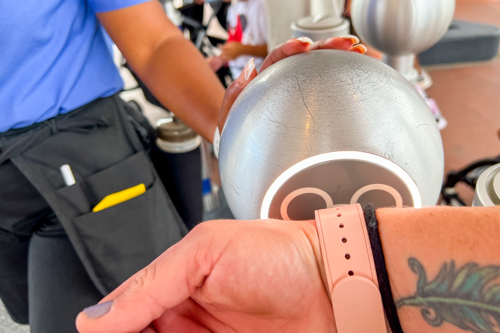 A person using a MagicBand to tap into a Disney park