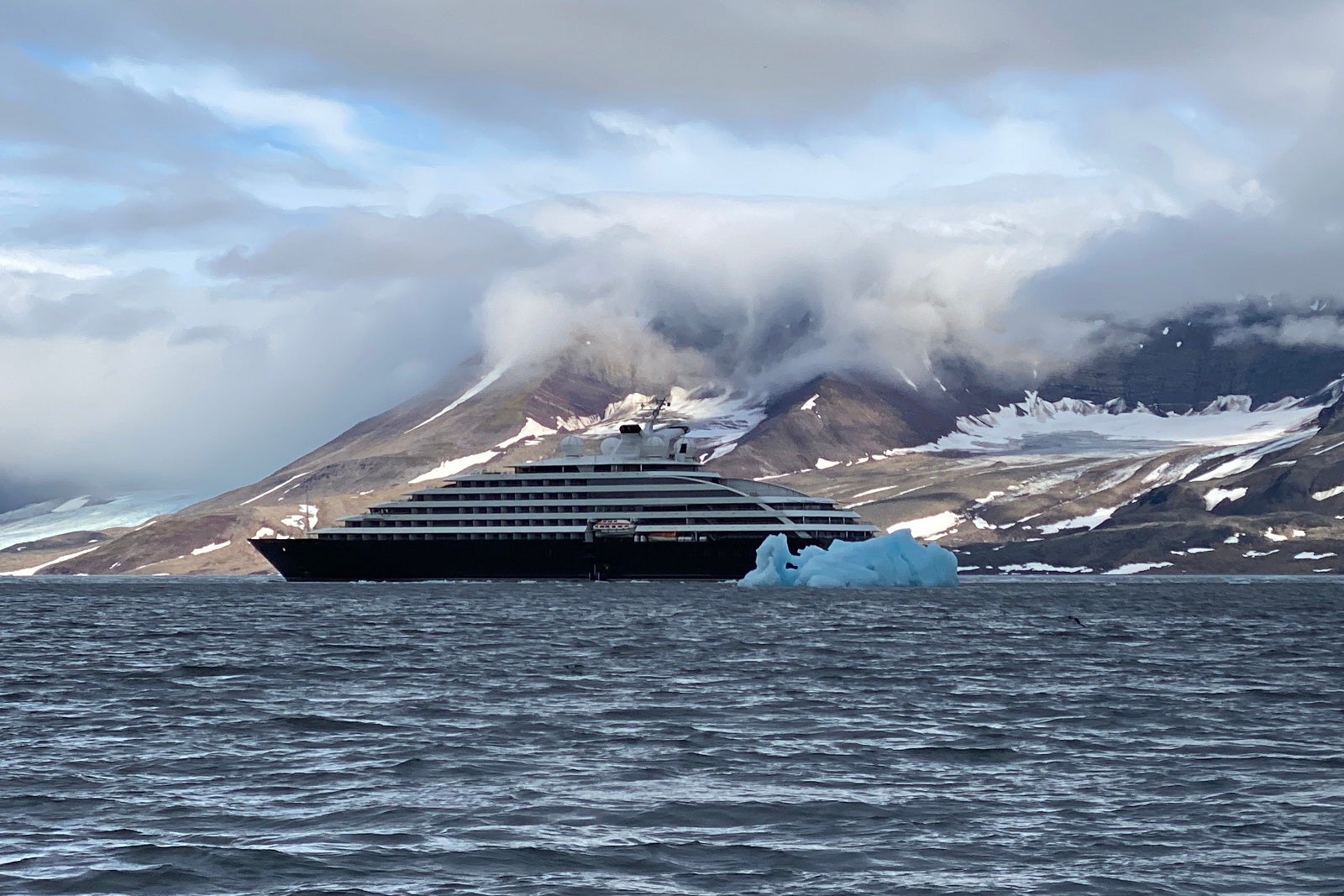 Scenic Eclipse floats behind a hunk of blue ice just off of Svalbard.