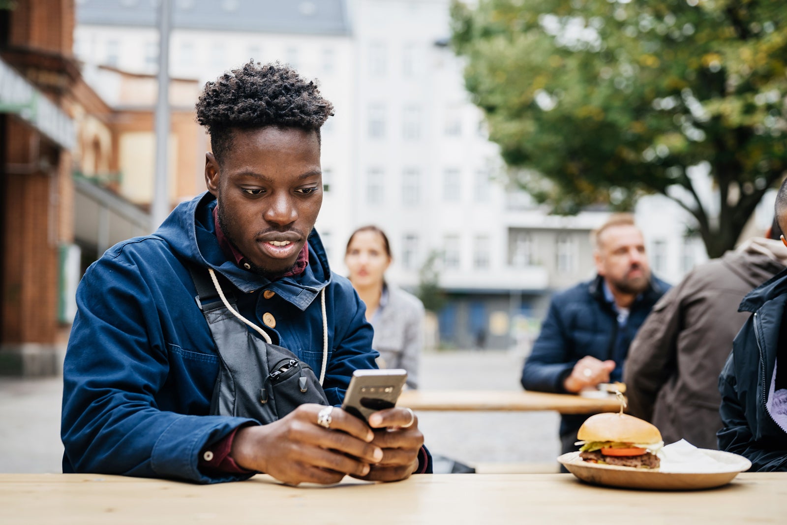 Man eating and using his smartphone