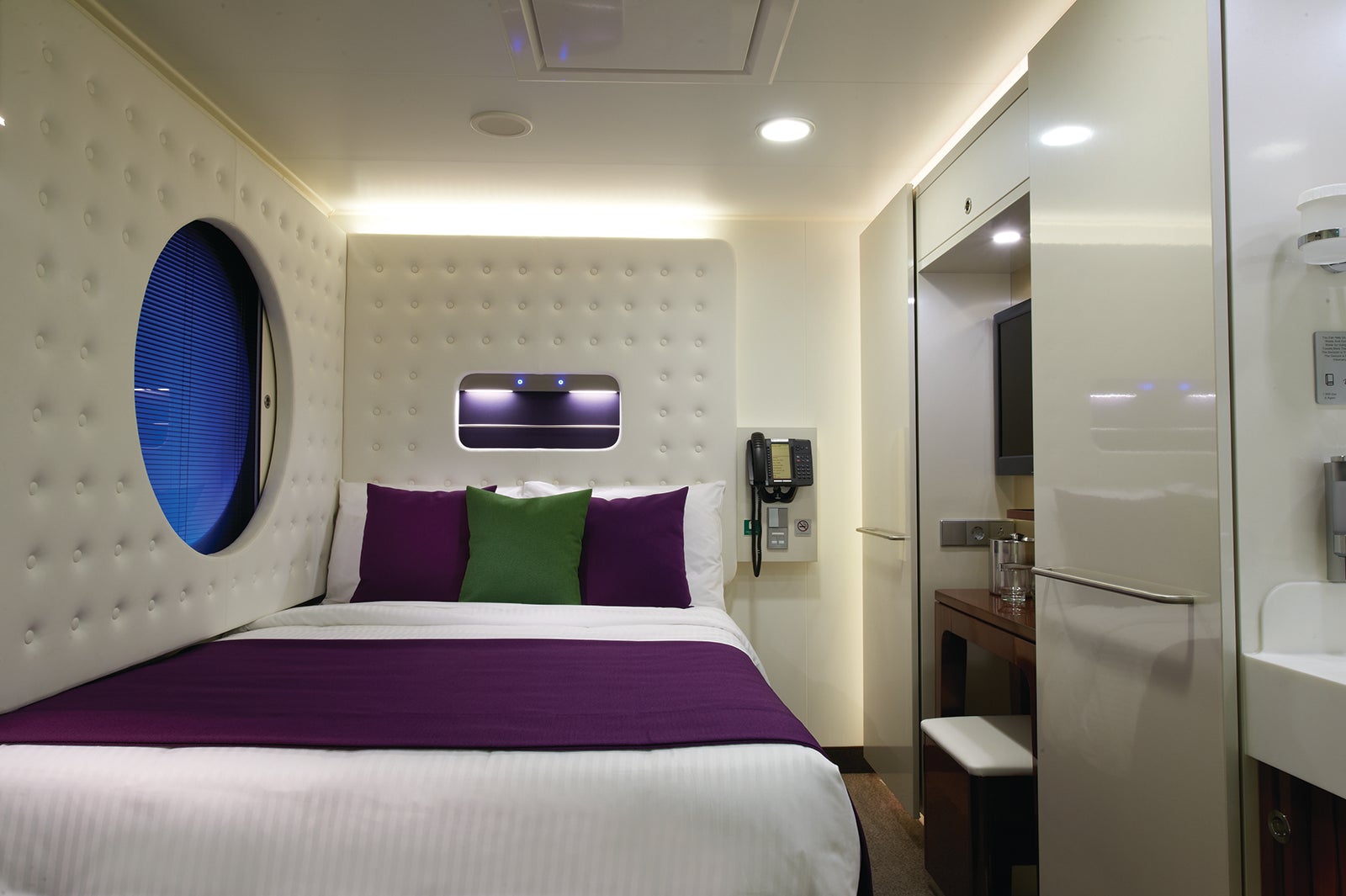 Cruise ship cabin for one person with round window facing the corridor.