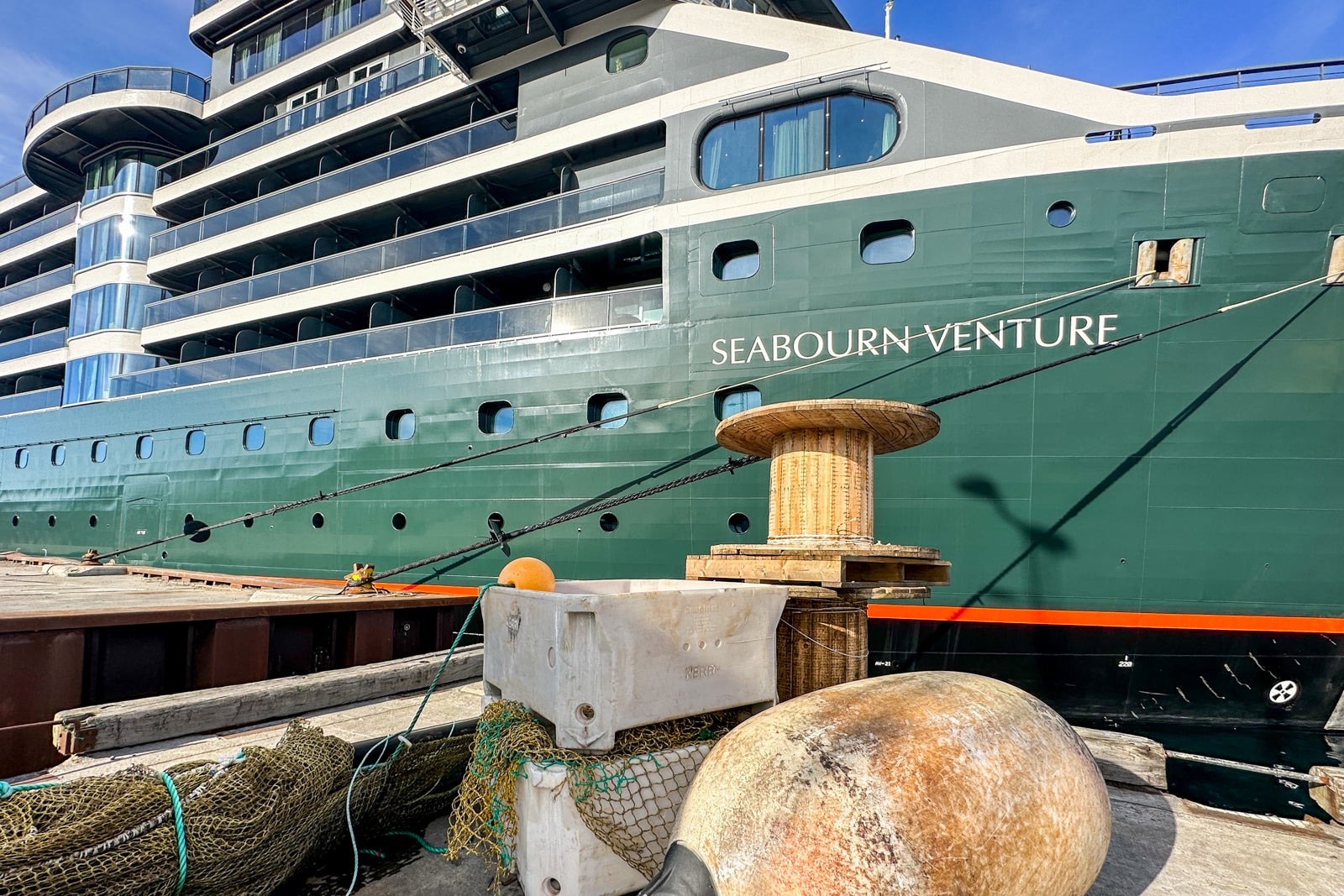 Close-up of a docked cruise ship with a green hull