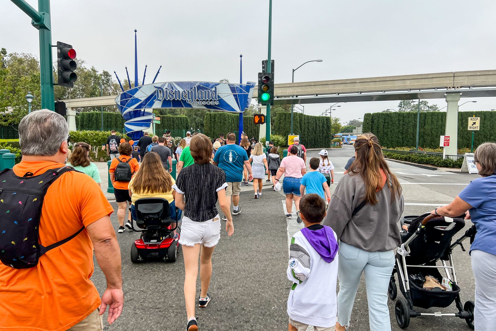 a group of people walking toward the entrance to Disneyland