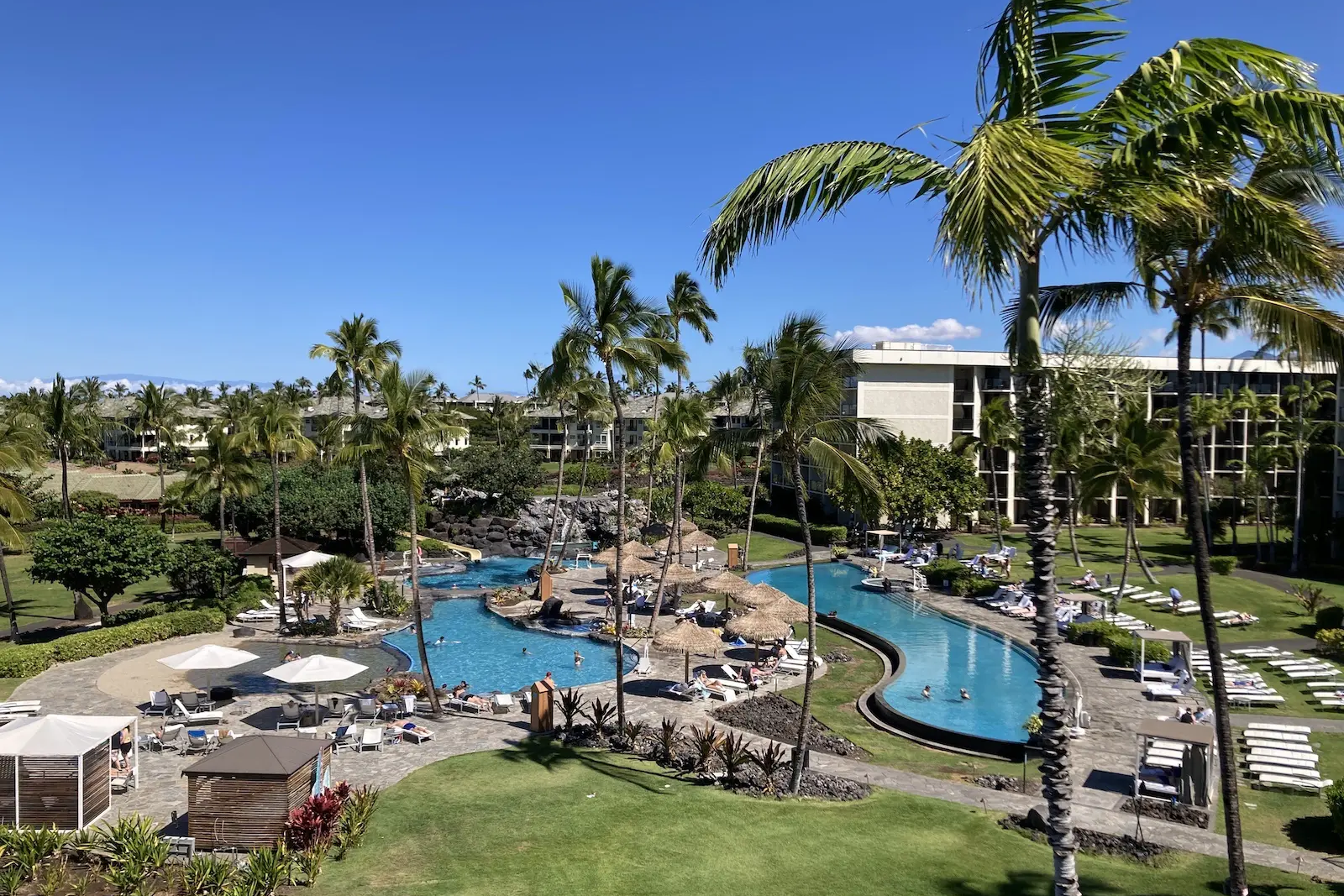 a large hotel complex surrounding multiple swimming pools