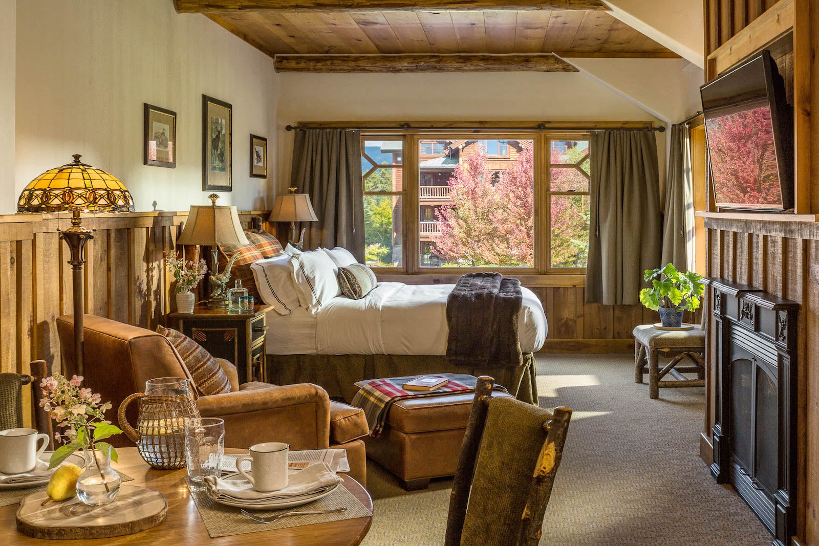 Lodge bedroom with fall trees outside window