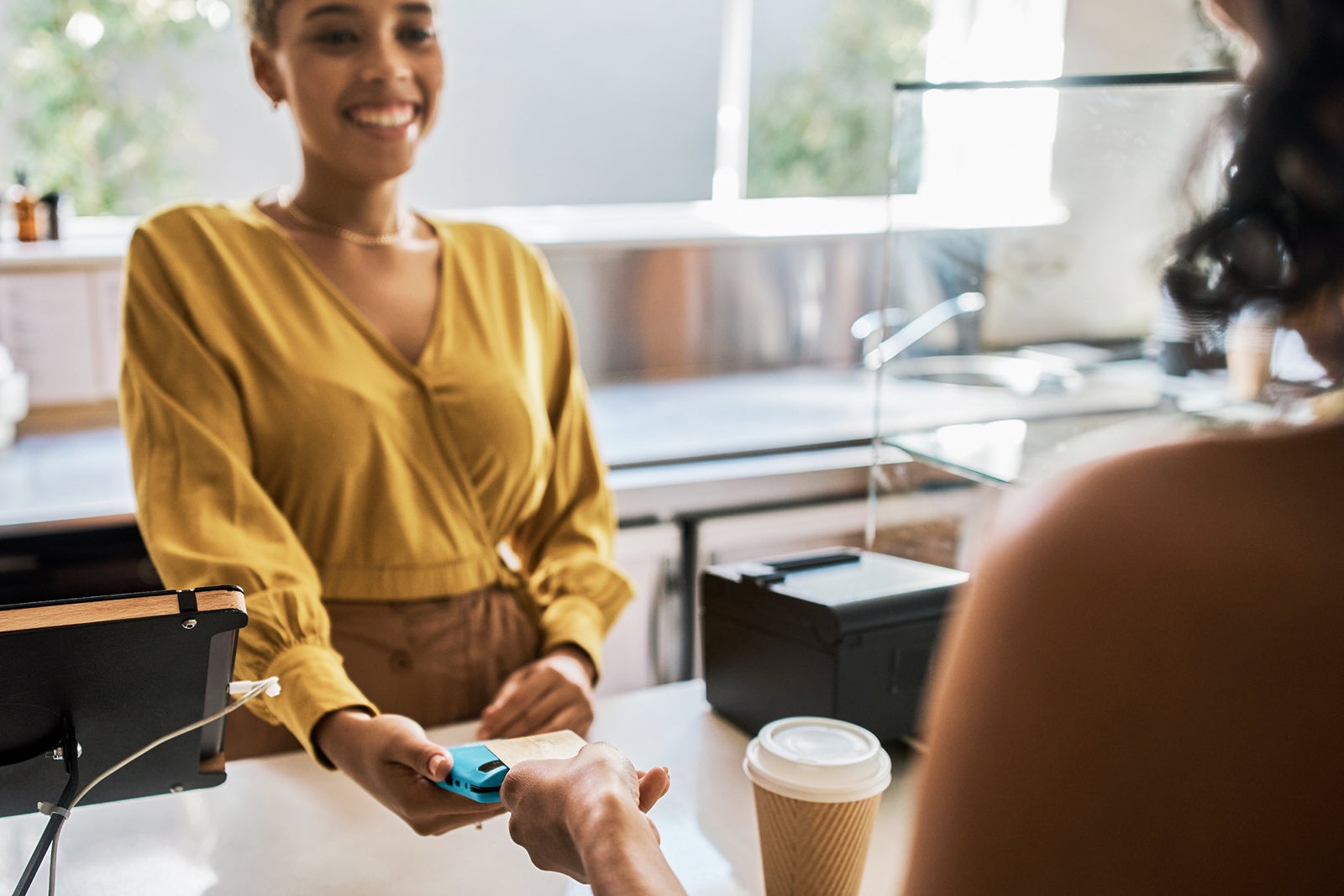 Woman checking out at a coffee shop with a credit card