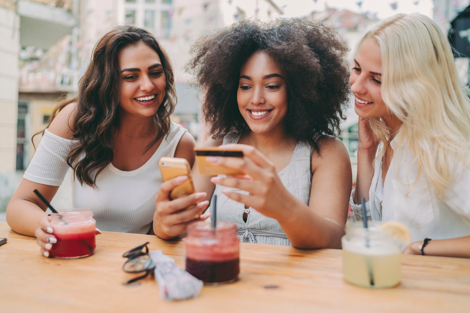 friends at a restaurant are looking at a smart phone together