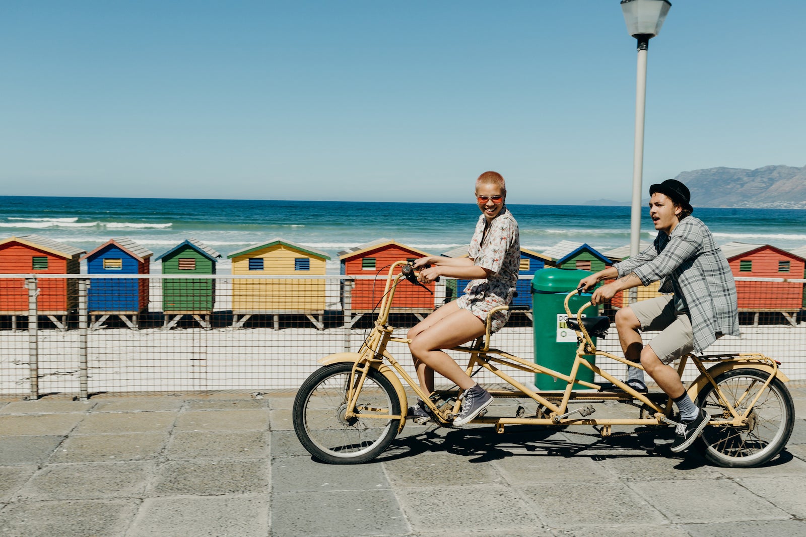 A young couple rides a tandem bicycle