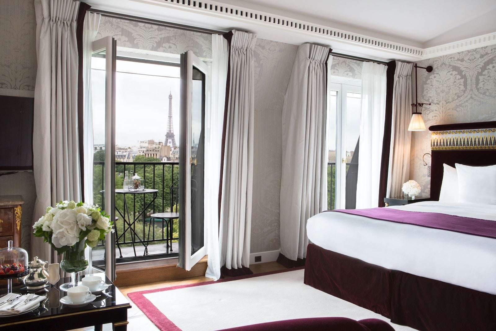 a luxury hotel room with balcony doors open
