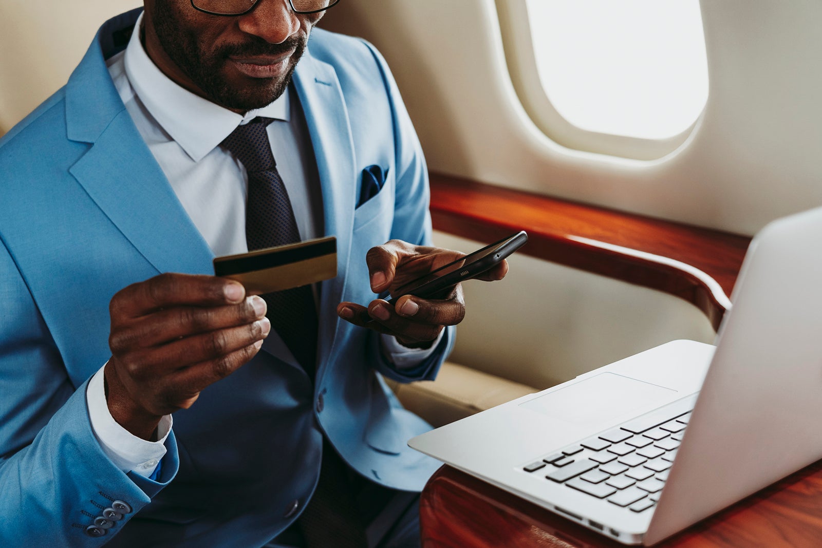 a man makes a credit card payment on his laptop during a flight