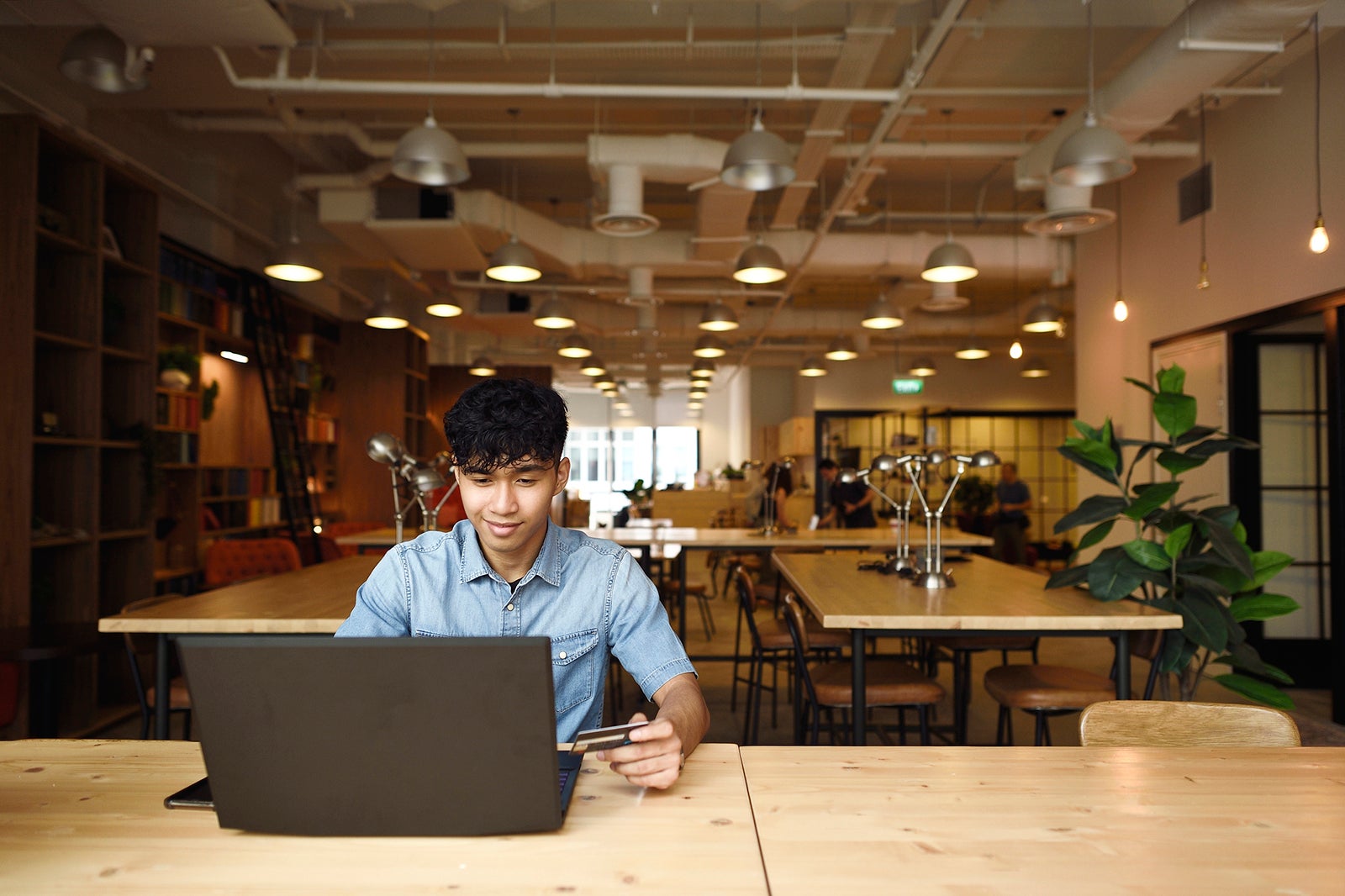 Teenage boy making online payment in a library