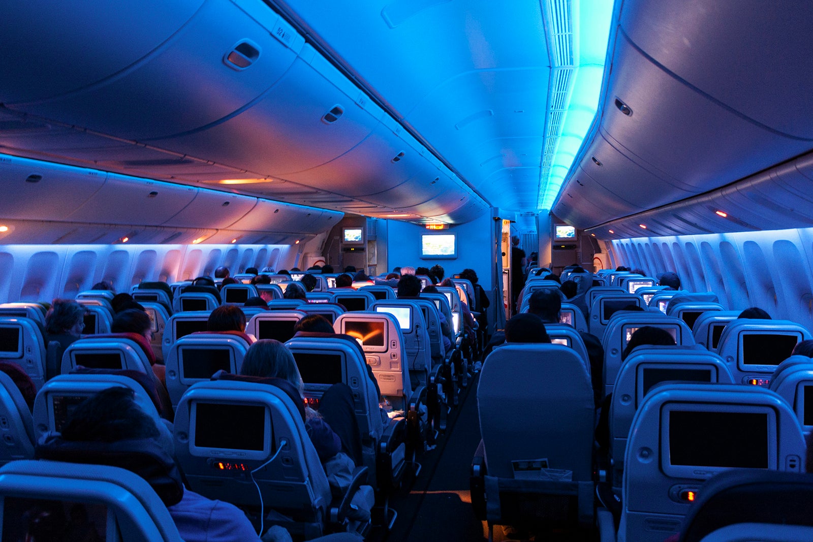 dimly lit interior of airplane with 3-3-3 seat arrangement