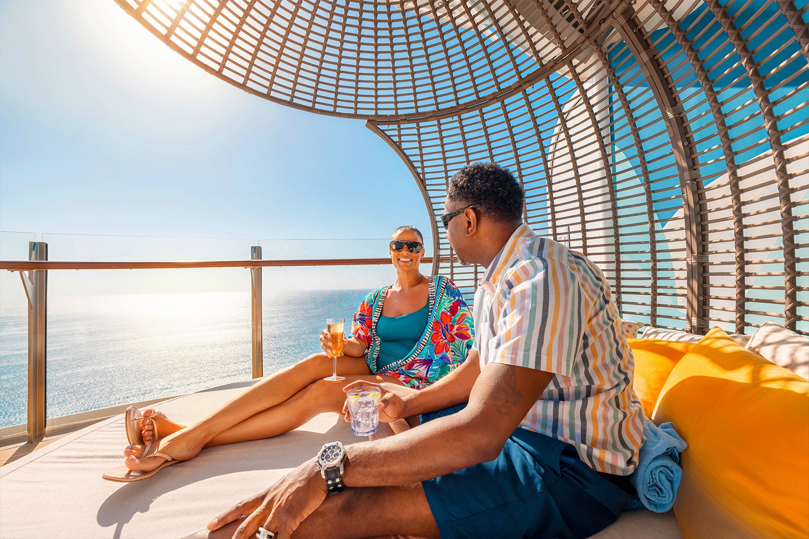 A couple sits in a cabana on a Royal Caribbean Cruise in the ocean.