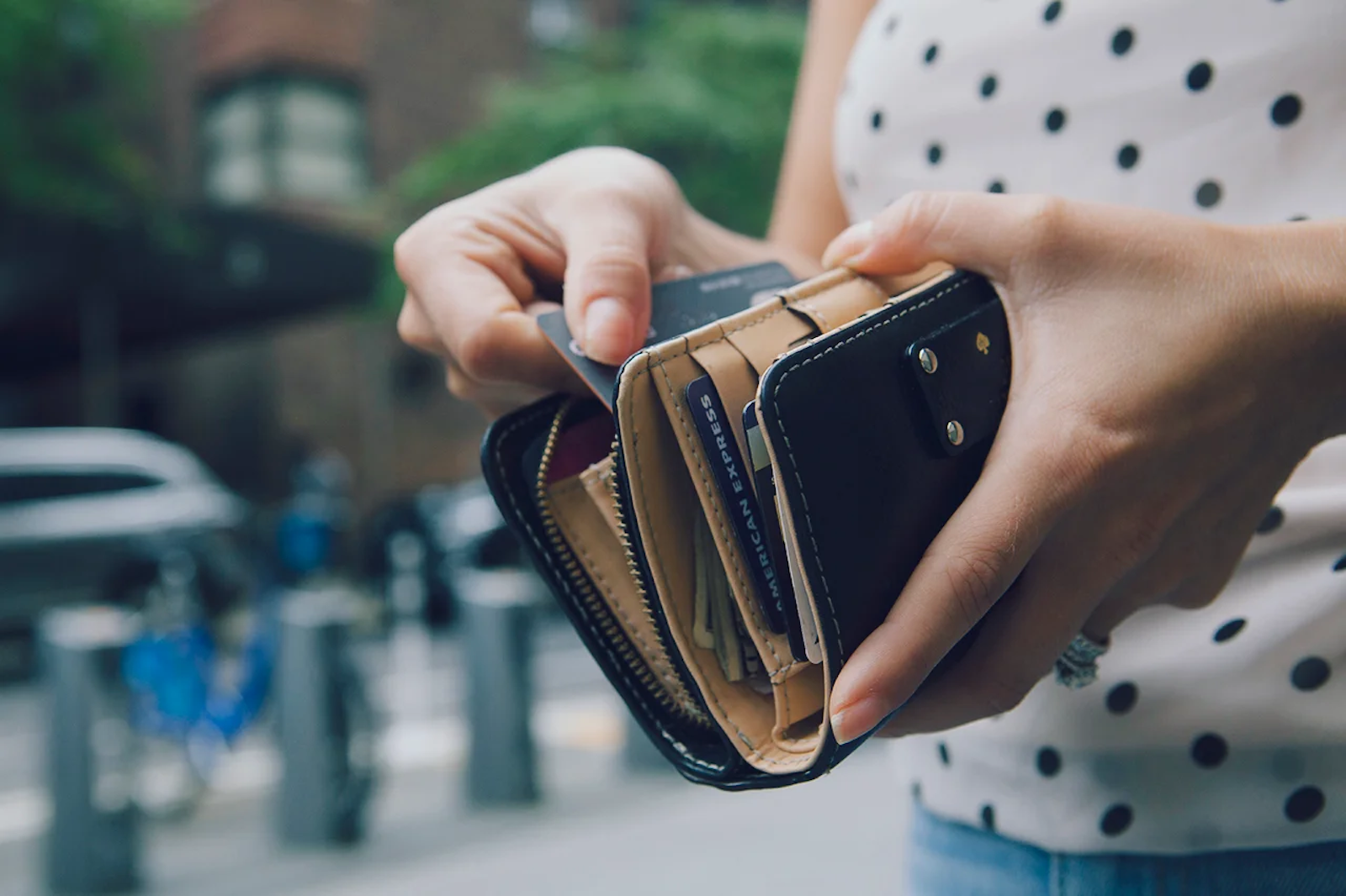 An unseen person holds a wallet with many credit cards