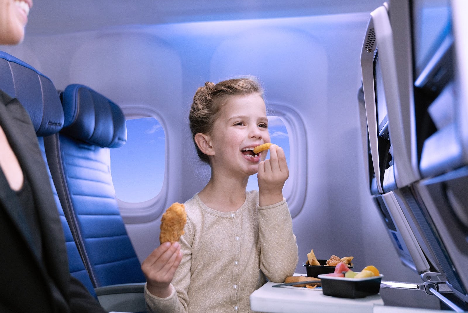 child on plane eating snack
