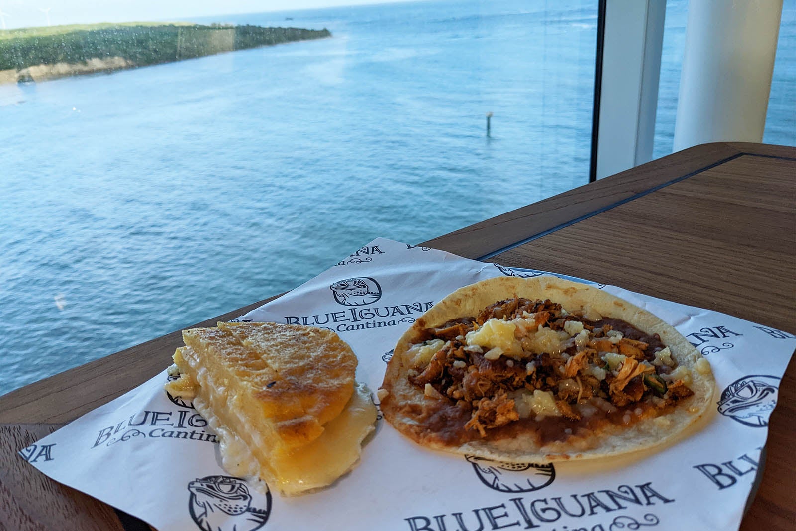 Breakfast of taco and arepa on cruise ship by window overlooking the ocean