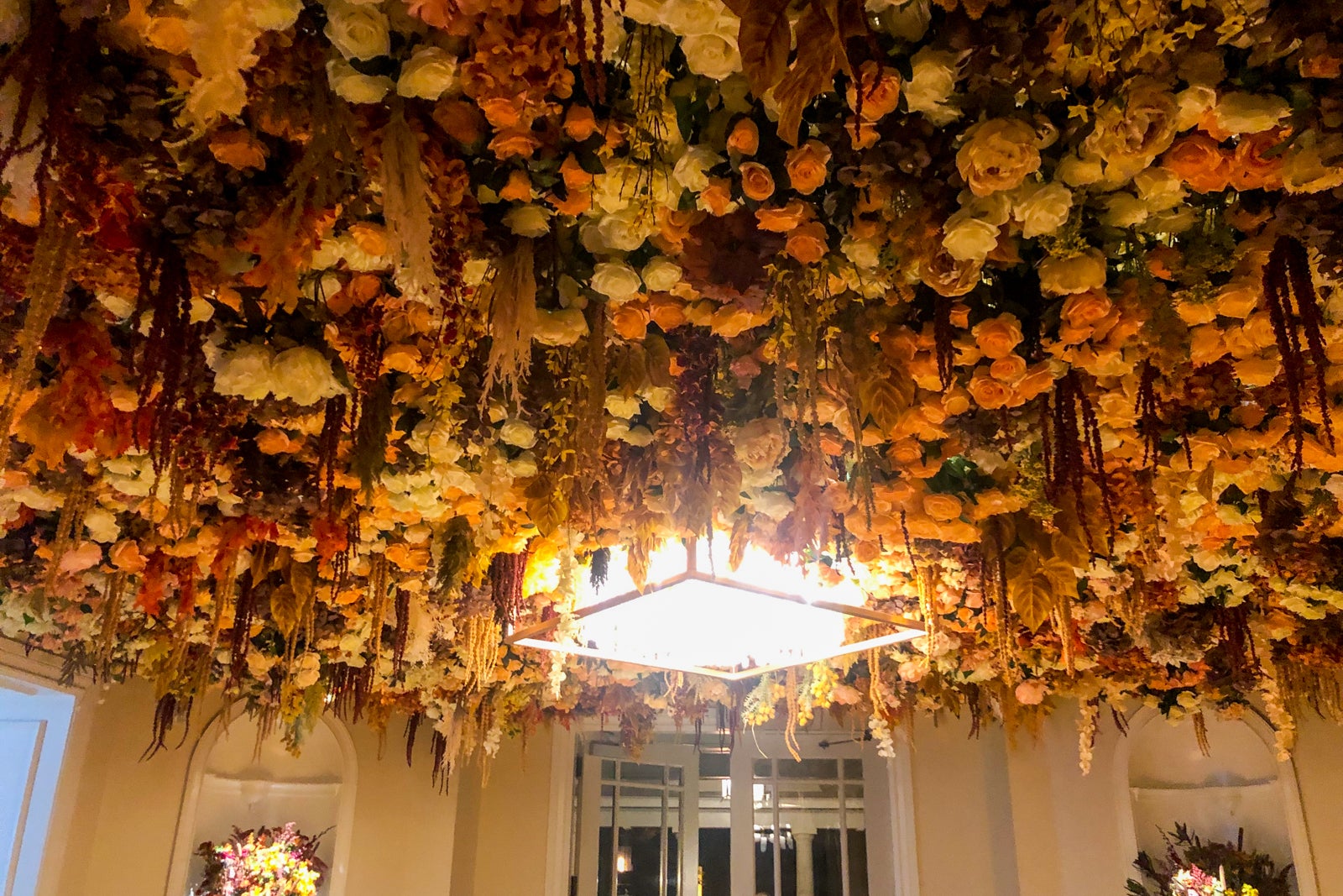 A view of the hotel entrance's chandelier decorated with fall foliage.