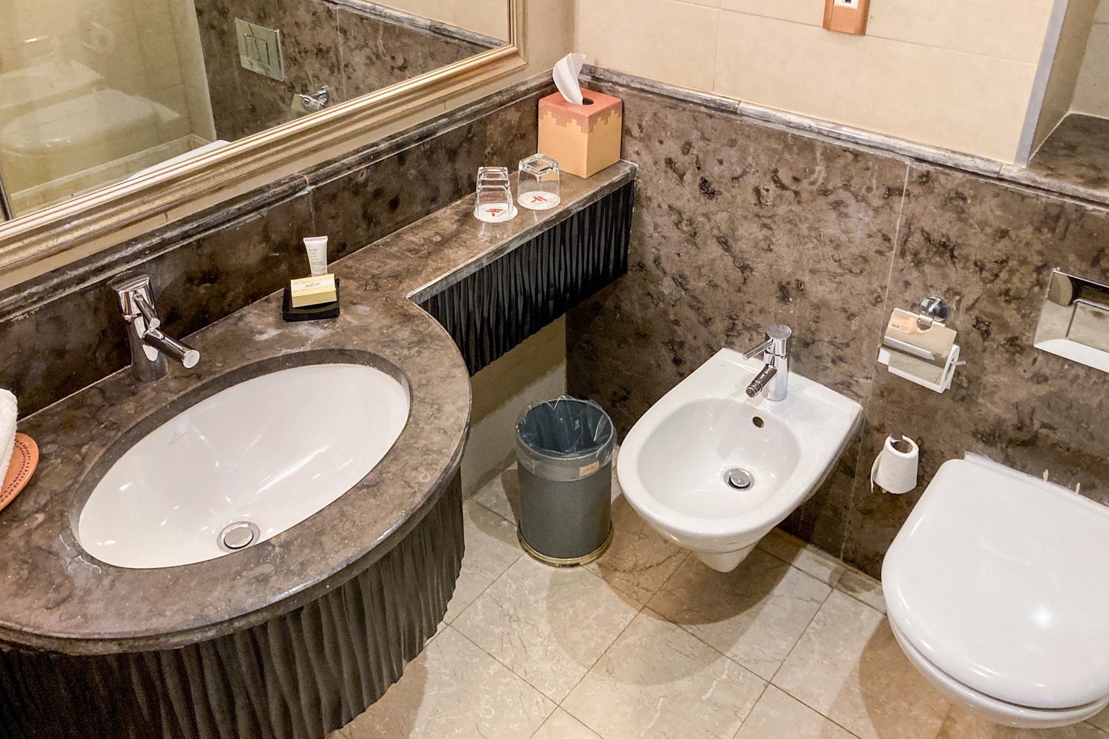 the sink, toilet and bidet in a hotel bathroom