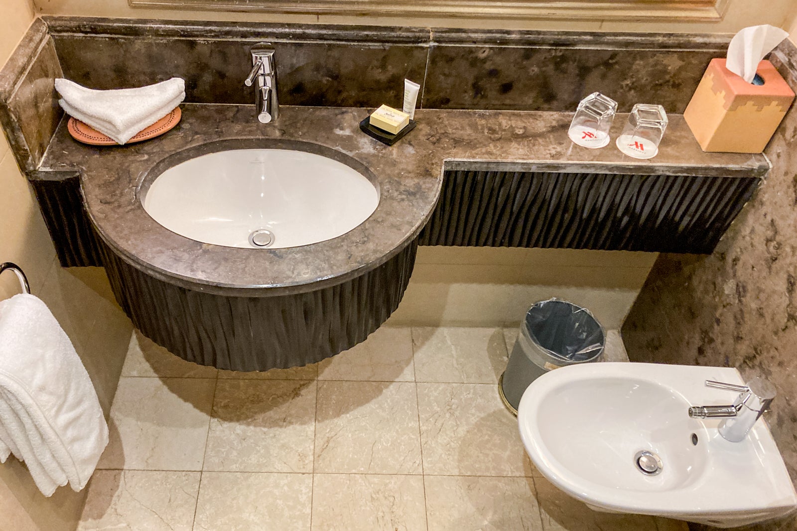 the sink, toiletries and bidet in a hotel bathroom