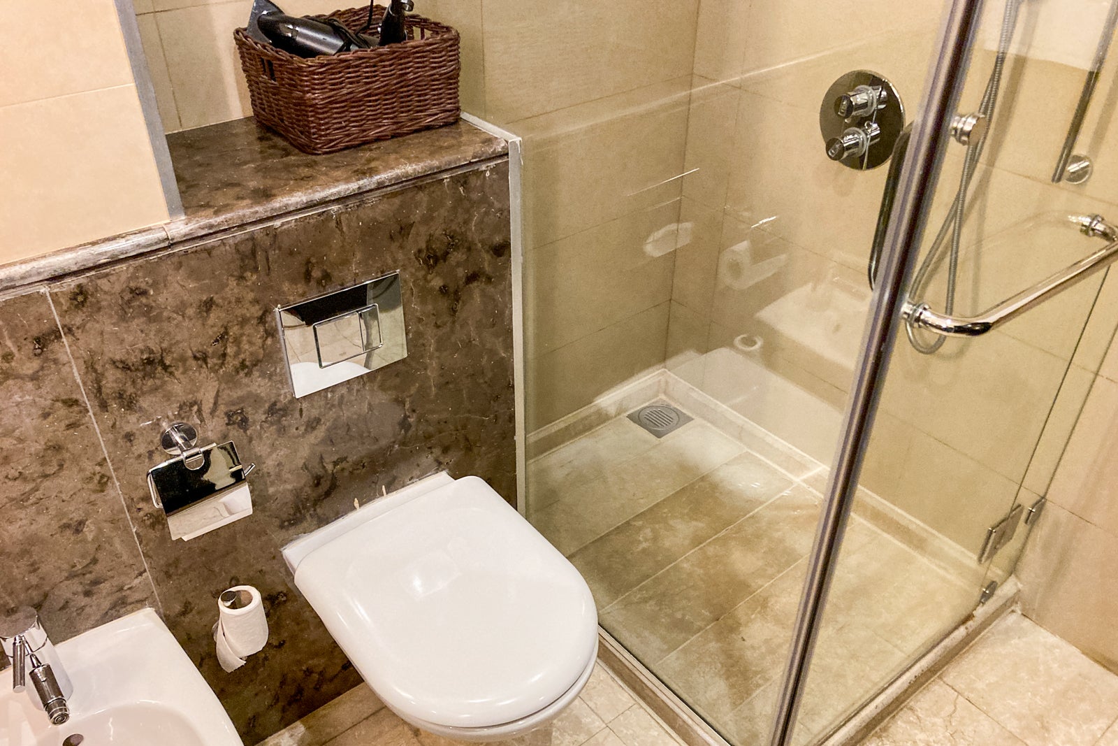 the toilet and glass shower box t in a hotel bathroom
