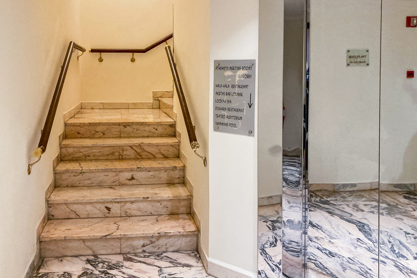 stairs next to a small elevator door