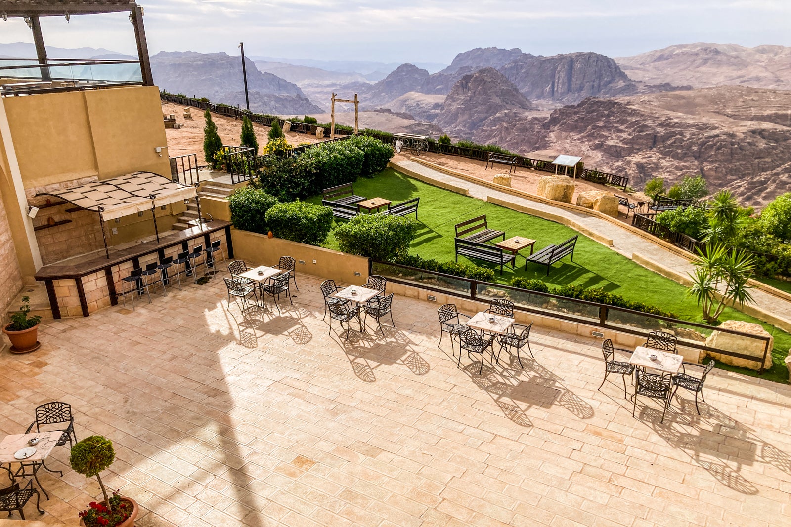 looking down at an outdoor area with dining and swimming pool at a hotel in the desert